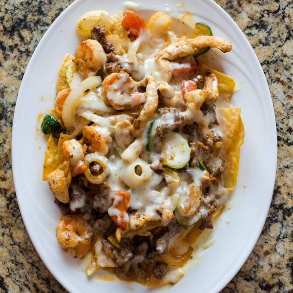 Los Amigos Don Juan's nachos with melted cheese, shrimp, chicken, beef, onions, and vegetables.