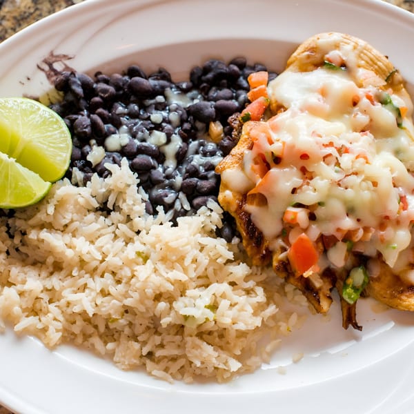 Grilled chicken with melted cheese and pico de gallo, served with rice, black beans, and lime.